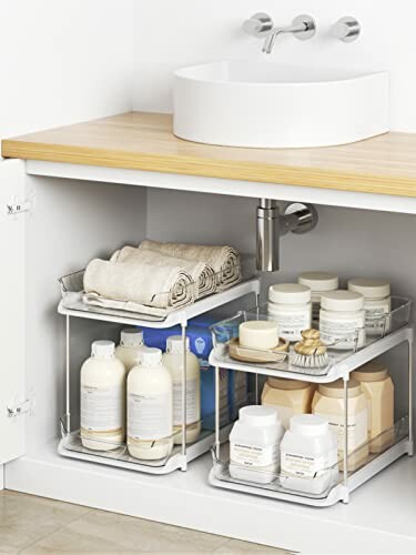 Under-sink storage with neatly arranged toiletries and towels.